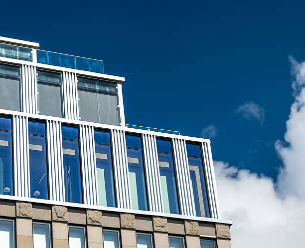 modern glass and steel building with blue sky reflection.