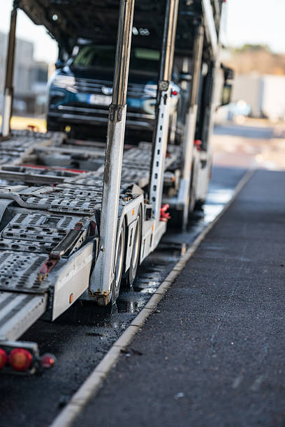istock transport truck loading ramp with vehicle in background.. 2213592757