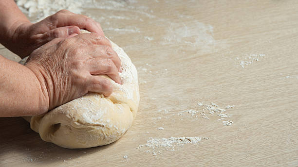 istock Raw homemade bread, preparing and kneading the bread before baking, on a wooden surface, selective focus. 2213593033