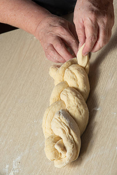 istock Raw homemade bread, preparing and kneading the bread before baking, on a wooden surface, selective focus. 2213593070