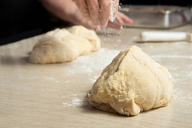 istock Raw homemade bread, preparing and kneading the bread before baking, on a wooden surface, selective focus. 2213593080