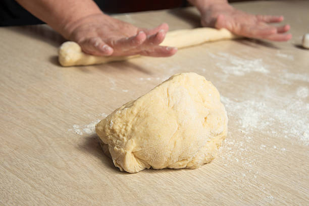 istock Raw homemade bread, preparing and kneading the bread before baking, on a wooden surface, selective focus. 2213593085