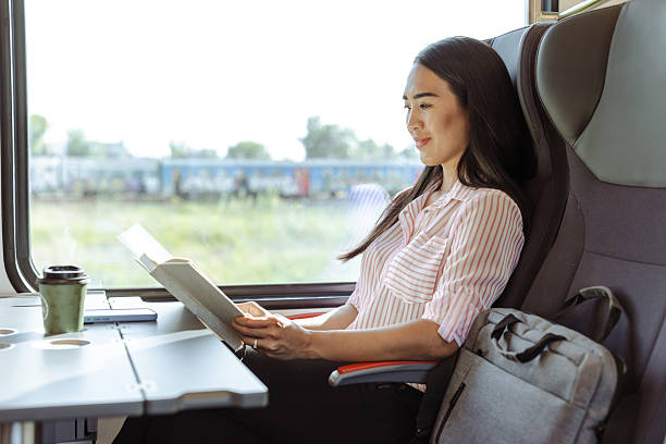 istock Woman reading a book while traveling on a train during the daytime 2213593472