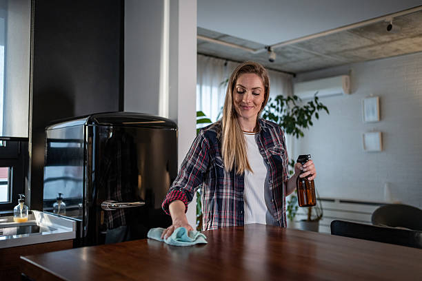 istock Woman cleaning kitchen counter with spray bottle 2213595539