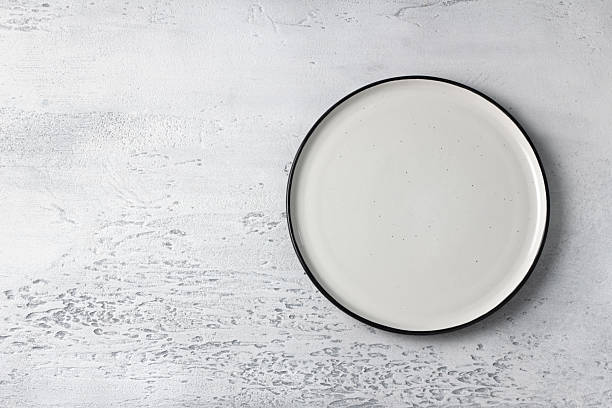 istock Empty white ceramic plate on light gray concrete background. Minimalist food or tableware mockup 2213597862