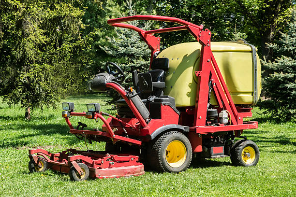 Springfield, Illinois, USA : June 3, 2025 Farmer drives a John Deere 8400 row crop tractor in his agricultural field. He is mowing the grass on the edge of his field.