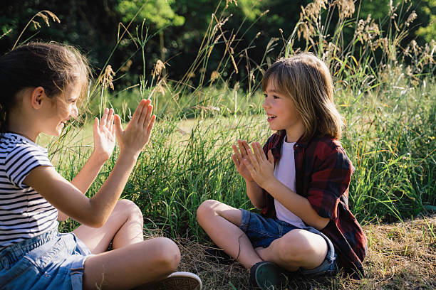 istock Children Playing Hand Clapping Game in Nature 2213602287