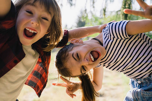 istock Joyful Kids Making Funny Faces in a Sunny Park 2213602311