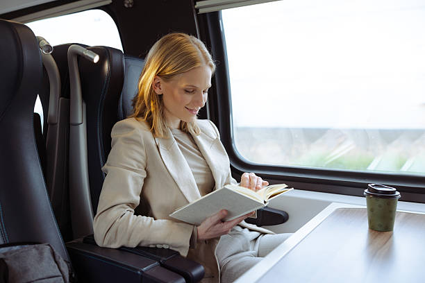 istock Businesswoman reading a book while traveling on a train 2213607750