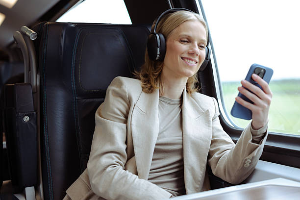 istock Businesswoman enjoying music while commuting on a train 2213608175