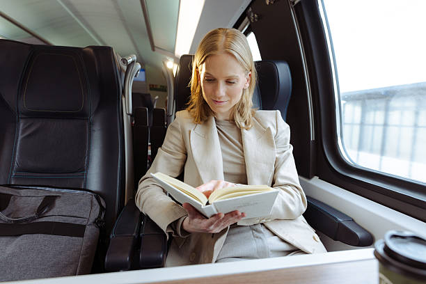 istock Businesswoman reading a book while traveling on a train 2213608265