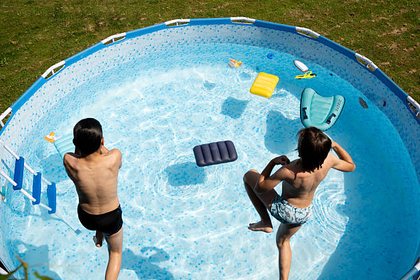 istock Boys  jumping in the swimming pool.  High angle view. 2213625068