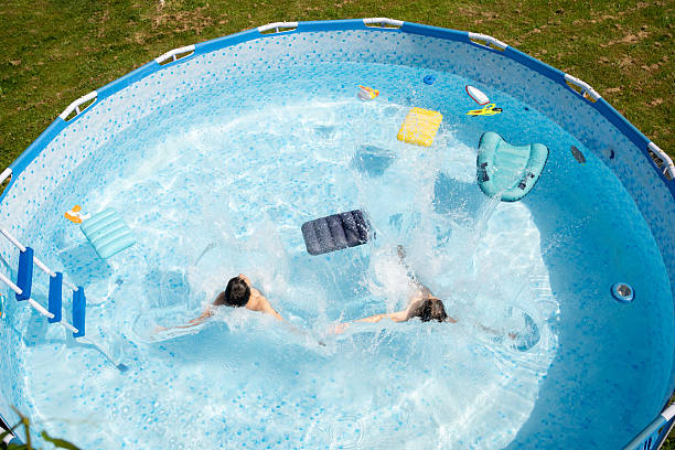 istock Boys  jumping in the swimming pool.  High angle view. 2213625073