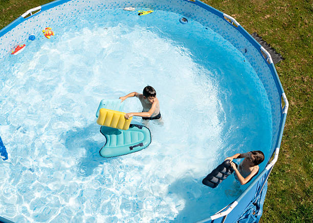 istock Boys  jumping in the swimming pool.  High angle view. 2213625077