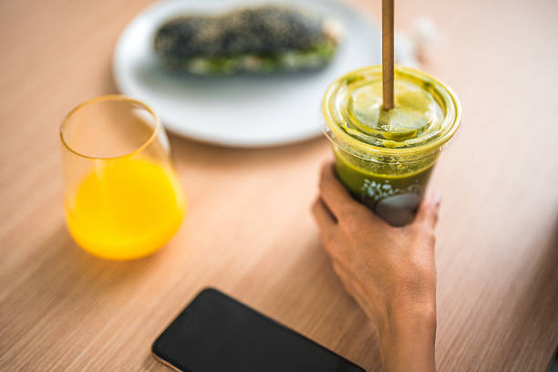 A woman at her workplace sips a nutritious smoothie during her lunch break.