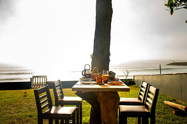 istock breakfast table with high stools on a sunny day in a garden facing the calm sea outside with close-up on cold coffee cups and rustic wooden pads 2213628693