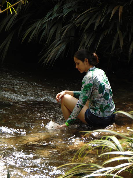 istock Beautiful woman touching the water 2213631549