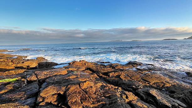 istock Experience the Serene Ocean View complete with Rocks set against a Bright Blue Sky above 2213631708