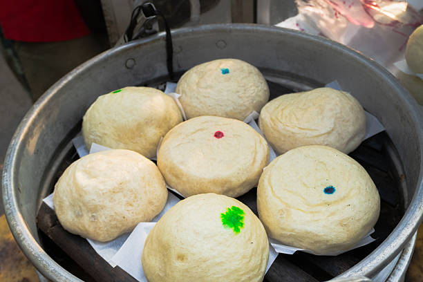 Baozi or Bakpao with various sweet fillings sold in street food centers. Chinese steamed food.