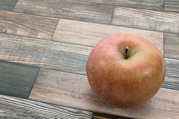 The red apple, with its glossy surface reflecting light, conveys the freshness of just being harvested. One bite reveals juicy flesh and a sweet and tart flavor that fills the mouth.