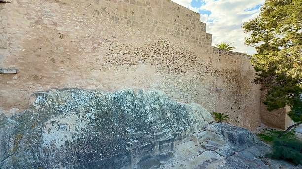 istock An Historic Stone Wall featuring a Window and remarkable Natural Rock Features can be seen 2213647245
