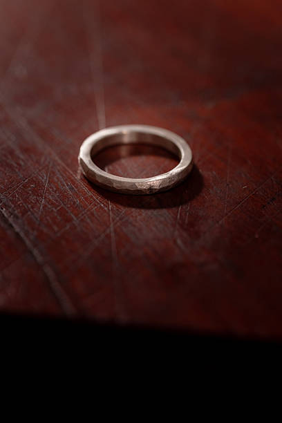 istock Hand-Forged Silver Ring with Hammered Texture on Wooden Surface 2213654624