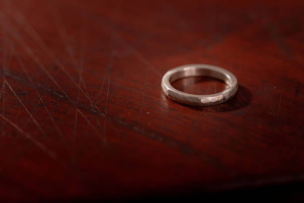 istock Hand-Forged Silver Ring with Hammered Texture on Wooden Surface 2213654653