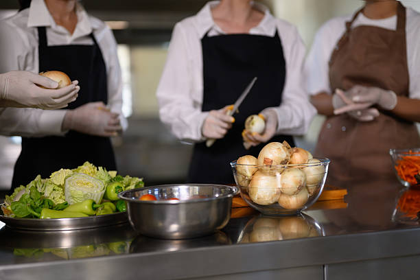 istock Group of cooking school students preparing fresh vegetables during a culinary class 2213655002