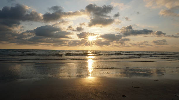 istock Sunset reflecting on wet sand with incoming waves and cloudy sky 2213656457