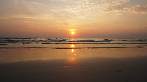 istock Golden sunset reflecting on wet sandy beach with incoming waves 2213657613