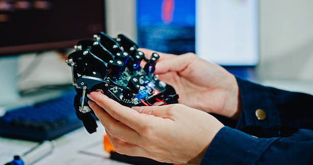 istock Close-up of Young female engineer examining and working on a robotic arm prototype in technology laboratory. AI and Robotics Development. 2213657703