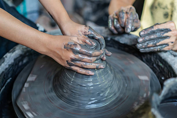 istock Close-up of hands shaping clay on a spinning pottery wheel. 2213657708