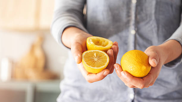 istock Woman holds cut and squeezed lemons in her hands 2213657861