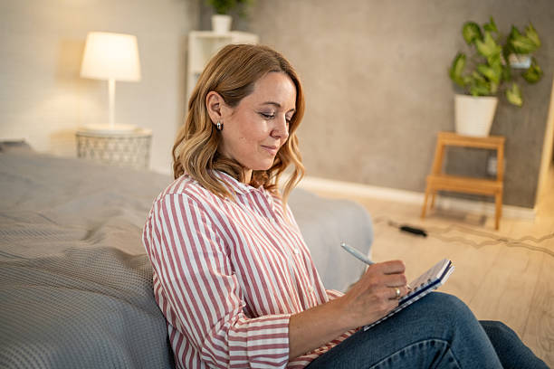 istock Woman writing on notepad in bedroom 2213658023