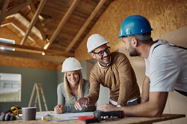 istock Happy couple talking about plans with manual worker at construction site. 2213659190
