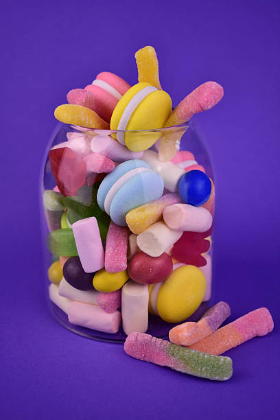 istock Many different candies in a jar on a blue background. 2213661796