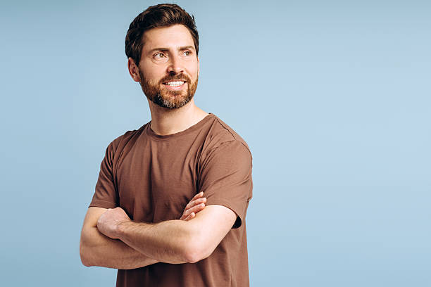 istock Confident man with crossed arms smiling and looking away 2213664837