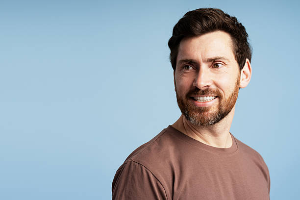 istock Smiling man looking away on blue background 2213664842
