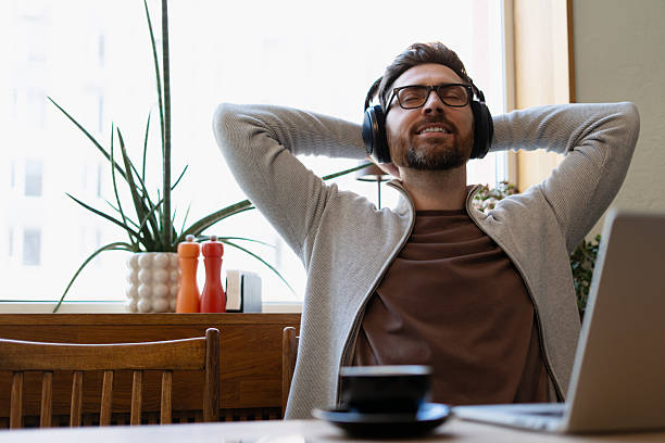 istock Freelancer enjoying music during work break in a cafe 2213665114