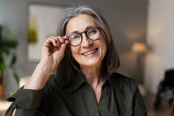 istock Smiling Senior Woman Adjusting Glasses and Looking at Camera 2213665513