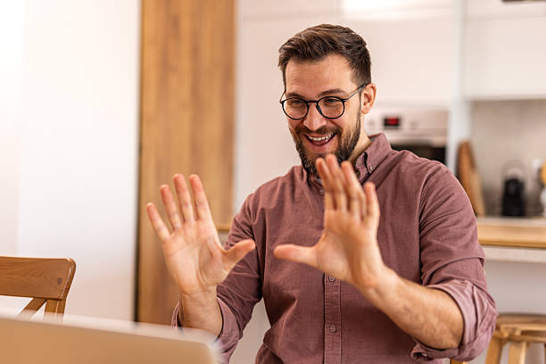 istock Freelance worker on video call from home, participating in an online meeting using a laptop in a modern kitchen. Ideal for illustrating remote work, digital communication, and home office productivity 2213667269