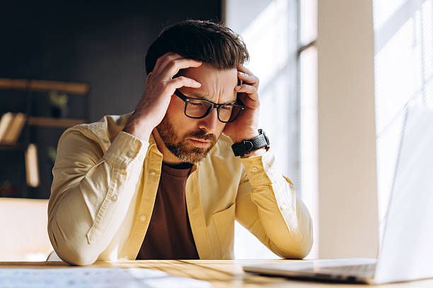 istock Stressed businessman having a headache while working on laptop 2213667490