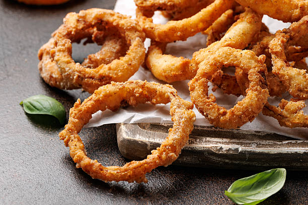 istock Deep fried onion rings on wooden board with sauce 2213667952