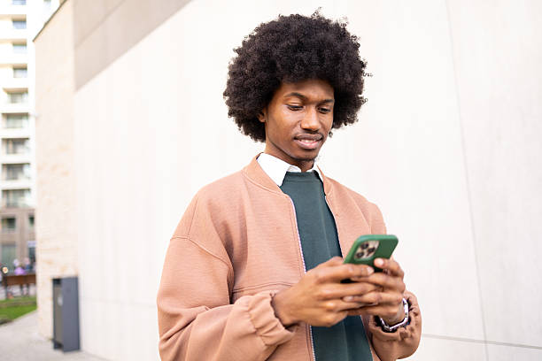 istock Young African American man using a smartphone outdoors in urban setting 2213670181