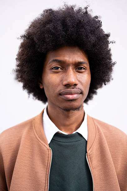 istock African American man smiling outdoors in casual clothes against a plain backdrop. He is looking at the camera 2213670819