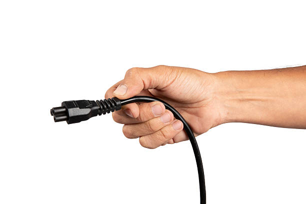 istock Male hand holding a black computer power cable isolated on white background 2213671005
