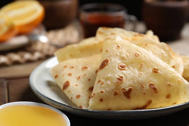 istock Delicious crepes and honey on table, closeup 2213671070