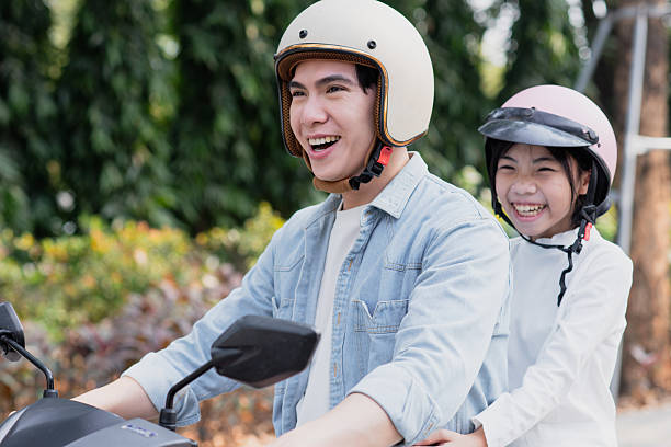istock Joyful moment shared by siblings riding a motorcycle in a sunny outdoor setting 2213671504