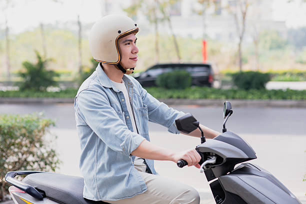 istock Young man in a helmet riding a scooter in an urban setting during daytime 2213671511