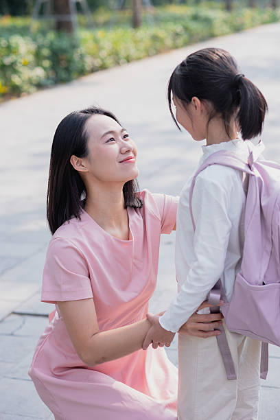 istock Supportive mother interacts with her daughter in a tranquil park setting during the afternoon 2213671543